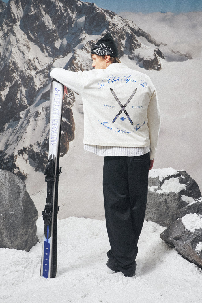 Person holding skis in a snowy mountainous area