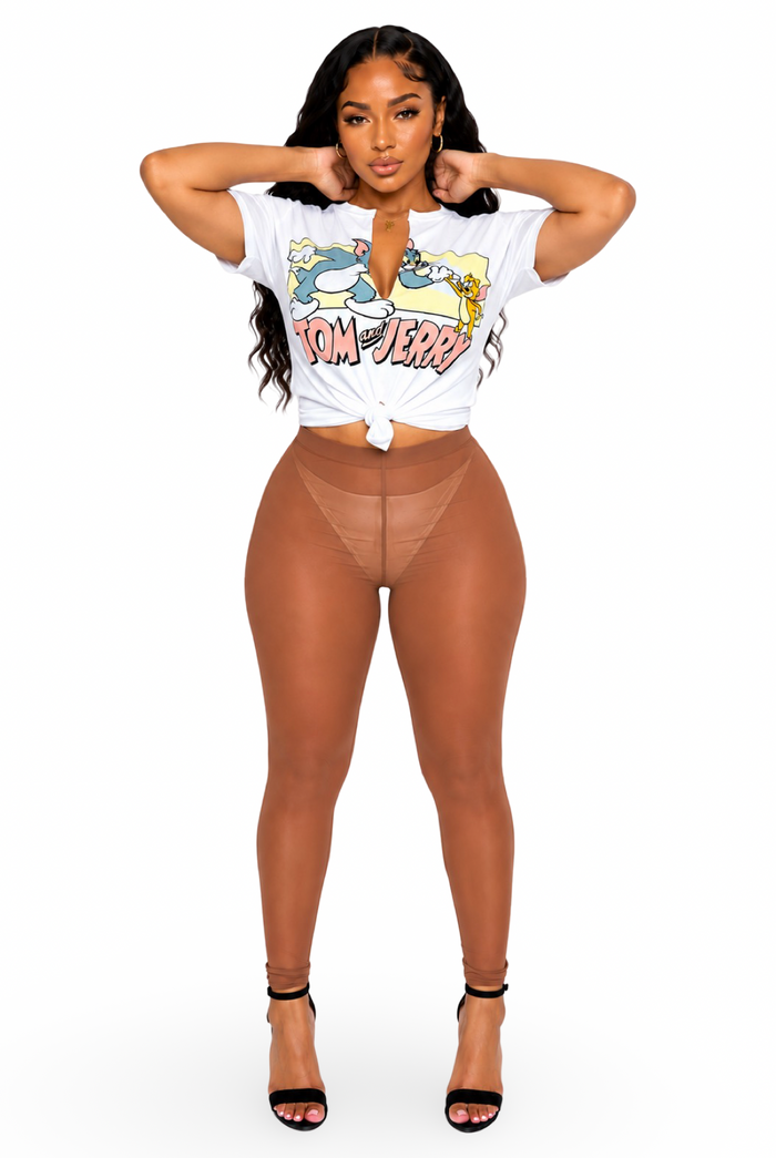 A woman modeling a white graphic t-shirt tied at the waist and sheer brown mesh high-waisted leggings, paired with black high-heeled sandals, against a plain white background.